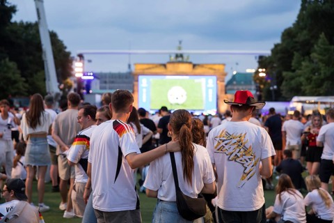 Fassball fans celebrate and gather information in the fan zone at the Brandenburg Tor after the