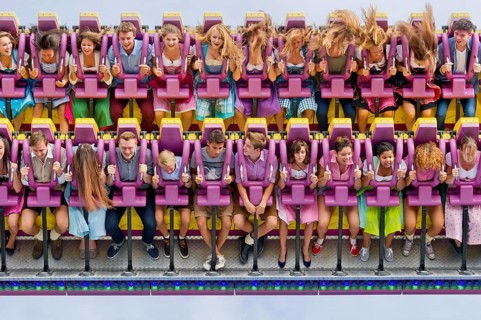Boys and girls swinging with blowing hair in giant swing Top Spin Fresh, swing, ride on the Wies'n,