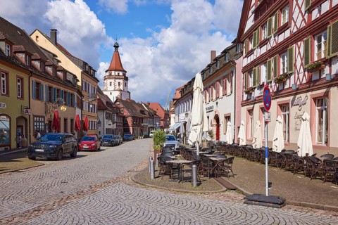Main street with outdoor area of a restaurant and the Niggelturm in Gengenbach, Black Forest,