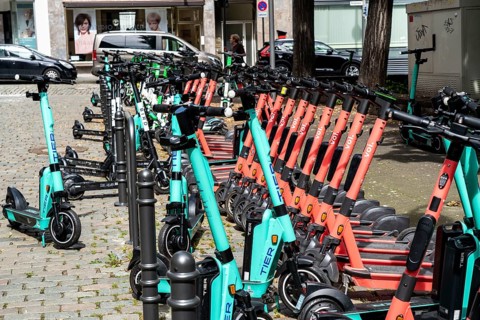 Electric scooters, e-scooters are parked in large numbers on the Burgmauer road, in front of