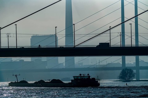 Dense fog slowly lifting, cargo ships on the Rhine near Düsseldorf, in front the Oberkassler