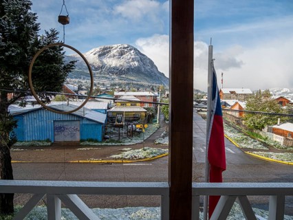 View out of a hotel to streets of Coyhaique, snow covered mountain Mt. Mackay, Patagonia, Chile,