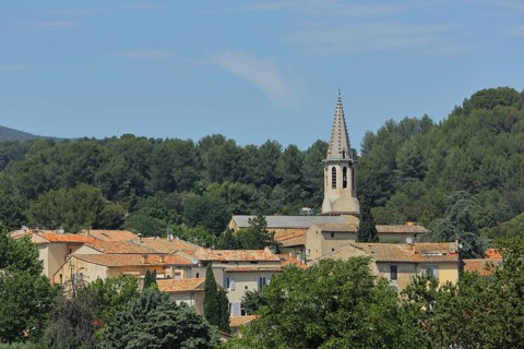View of mountain village with church tower of Saint Etienne in Cadenet, St, Luberon, Vaucluse,