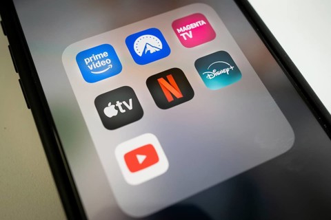 Streaming app icons on smartphone screen, including Netflix, AppleTV, Prime Video, Magenta TV,