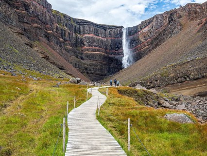 Waterfall Hengifoss, basaltic layers interwoven with red sedimentary layers, wooden boardwalk for