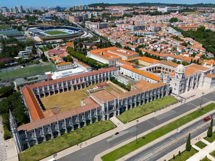 Aerial view of a large monastery in an urban landscape with green areas and urban structures in the