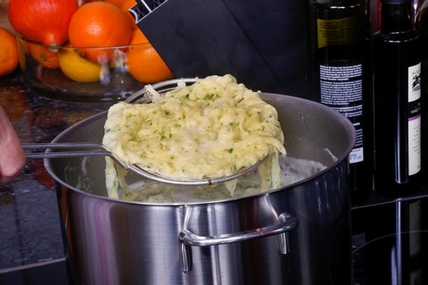 Swabian cuisine, preparation of herb spaetzle for roast beef, scooping spaetzle from boiling water,