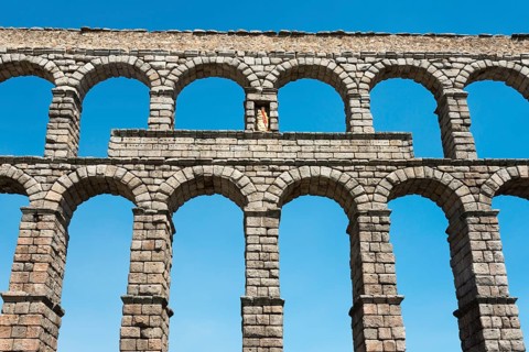 Ancient stone aqueduct with several arches in front of a blue sky, Aqueduct, Segovia, Castilla y