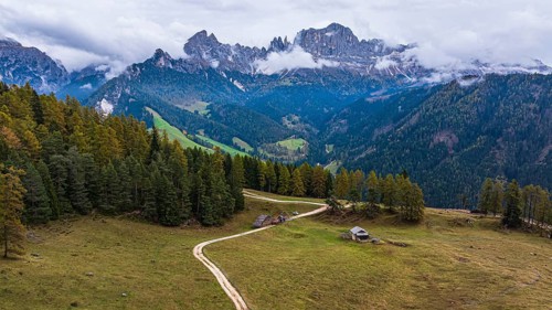 Alpine meadow Wuhnleger, behind the peaks of the rose garden, shrouded in fog, drone shot,
