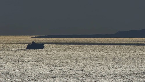 Silhouette of a ship on the glittering sea at sunset, calm evening mood, departure of the Bluestar