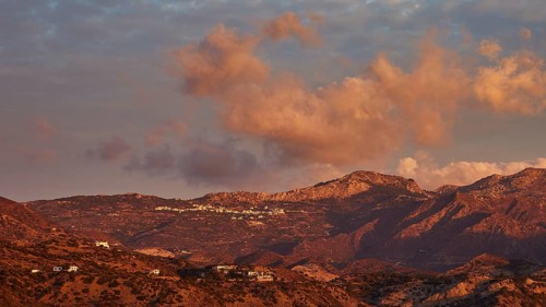 Mountain landscape at sunrise with dramatic clouds and a warm, atmospheric ambience, Pigadia, town
