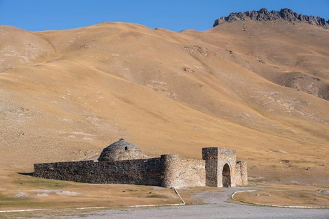 Historic caravanserai Tash Rabat from the 15th century, with yellow hills, Atbashy district in the