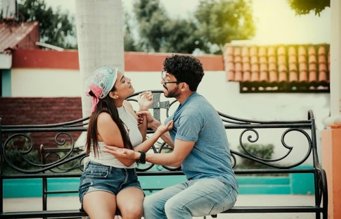 Man arguing with girlfriend sitting in a park. Young couple arguing sitting on a park bench,