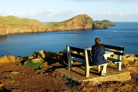 Hiker resting on bench at rocky coast, peninsula Ponta de Sao Lourenco, Madeira, Portugal, Hiker