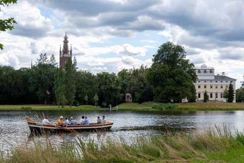 Gondola travelling past the castle and the Bible Tower in Wörlitz Park, Wörlitz, Saxony-Anhalt,