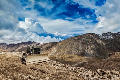 Bulldozer on road in Himalayas. Ladakh, Jammu and Kashmir, India, Asia