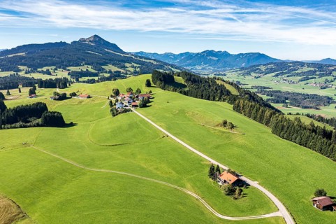 Aerial view of rural road in meadows, ridge Elleghöhe near Wertach, mountain Grünten in the back,