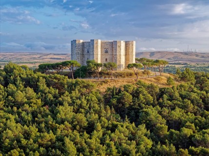 The Castel del Monte, an octagonal hilltop castle from the 13th century, stands on a wooded hill in