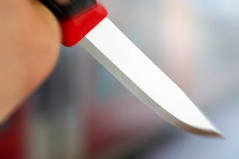 Symbolic image of a knife attack: close-up of a knife in a man's hand