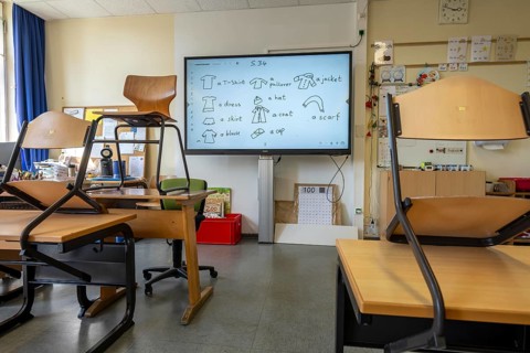 Classroom of a fourth grade, after school, the building is older but in good condition, modern