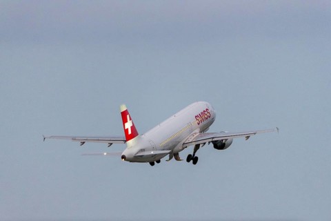 A Swiss aeroplane takes off into the sky with a clear blue background, Stuttgart