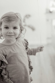 A smiling child holds a balloon in a black and white picture