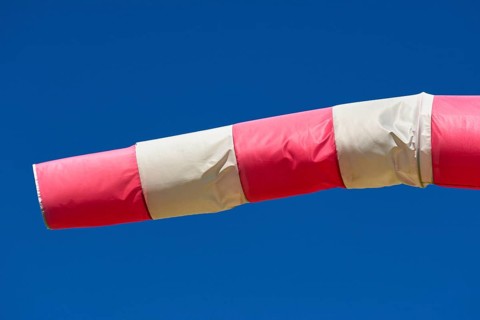 A red and white windsock blows against a clear blue sky, Germany, Europe