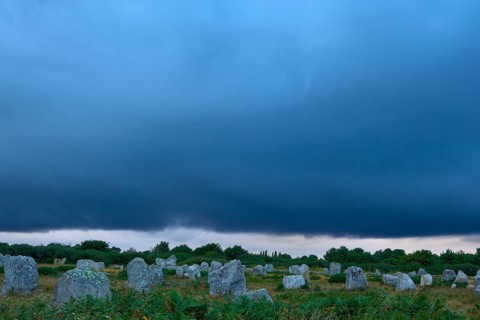 Neolithic menhirs, standing stones in Carnac with dramatic stormy sky, Carnac, Quiberon, Morbihan,