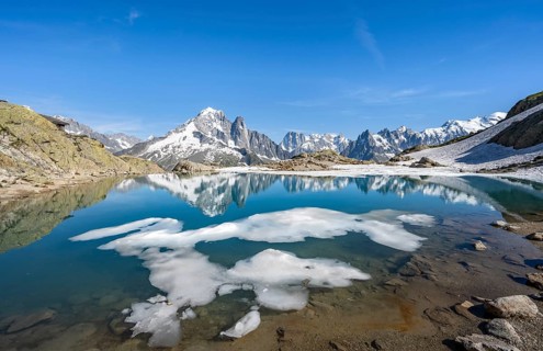 Mountain landscape with mountain lake and ice floe, water reflection in Lac Blanc, mountain peak,
