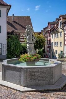 The Schnabelgiere fountain in front of historic half-timbered houses with the central figure of the