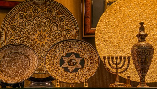Gold-decorated decorative plates with intricate patterns and symbols, including a menorah and Star