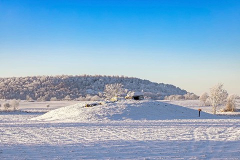 Passage grave on a hill in a beautiful winter landscape with snow and hoarfrost in the countryside,
