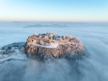 Aerial view of the Hegau volcano Hohentwiel with Germany's largest fortress ruins on a cold, foggy