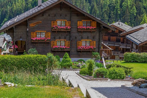 Modern chalet with wooden shingle roof and flower boxes in front of the windows, Grimentz, Val