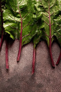 Fresh, green leaves, stem with beet leaves, on the table, top view, rustic, no people