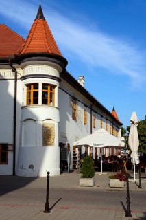 Historic building with a pointed roof and an outdoor terrace on a cobbled street, town hall,