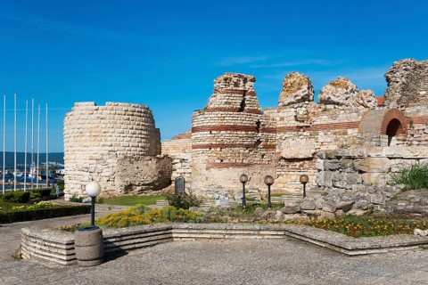 Sunny view of old ruins with blue sky and sea view, symbolising historical significance and