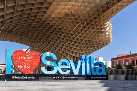 Welcome sign in various languages in front of the imposing architecture of the Metropol Parasol,