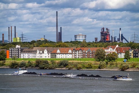 Cargo ship loaded with coal, on the Rhine near Duisburg-Laar, houses on Deichstraße, industrial