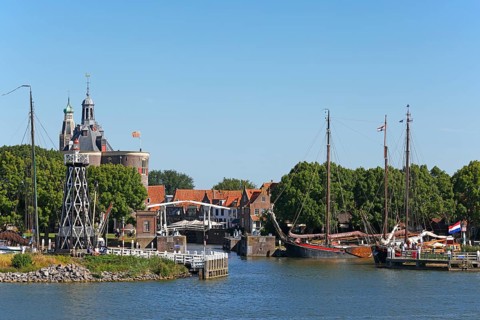 Town view of Enkhuizen with harbour entrance, lighthouse and historic old town with defence tower