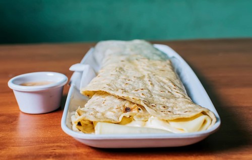 Close up of a Nicaraguan quesillo served on wooden table. Top view of Nicaraguan Quesillo on a