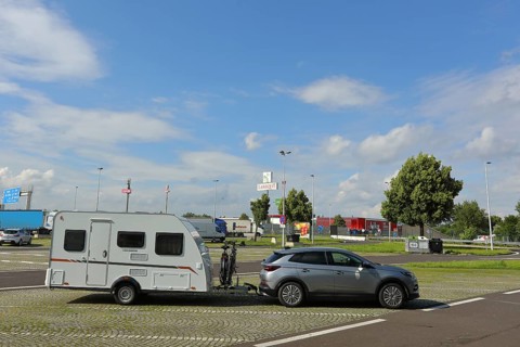 Car with caravan standing on a motorway service area, Tank und Rast, Caravan, service area near