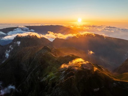 Aerial drone view of mountains over clouds near Pico Ruivo on sunset. Madeira island, Portugal,