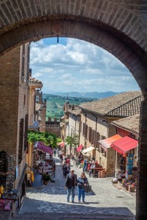 Archway and street with people in the medieval Gradara Castle, Marche, Italy, Europe