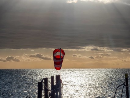 Windsock at sunrise over the sea in the Strait of Magellan, Punta Arenas, Chile, South America