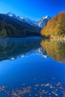 Mountains reflected in lake, fog, morning light, autumn colours, Riessersee, Waxensteine behind,