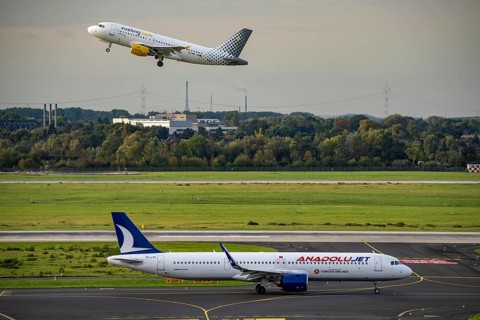 Düsseldorf Airport, Vueling.com Airbus on take-off, Anadolujet Airbus on the taxiway for take-off