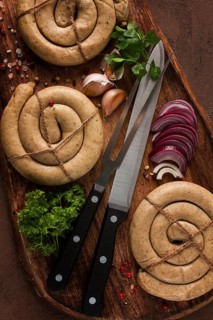 Raw spiral sausages, on a wooden board, top view, with spices, no people
