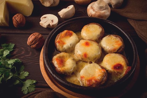 Traditional Georgian dish, appetizer, stuffed mushrooms, Sulguni cheese, baked in a Ketzi clay pan,