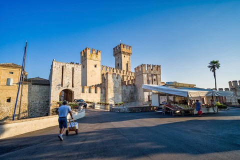 Market stall in front of Castello Scaligero, Sirmione, Lombardy, Italy, Europe